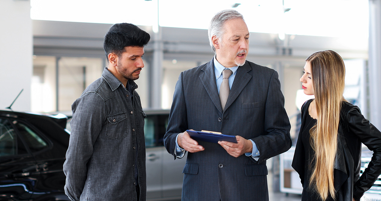 Couple speaking with a Mazda financing team member about refinancing