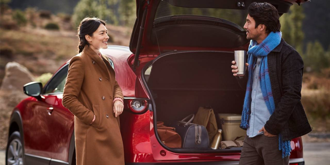 Couple loading the cargo area of a pre-owned Mazda SUV