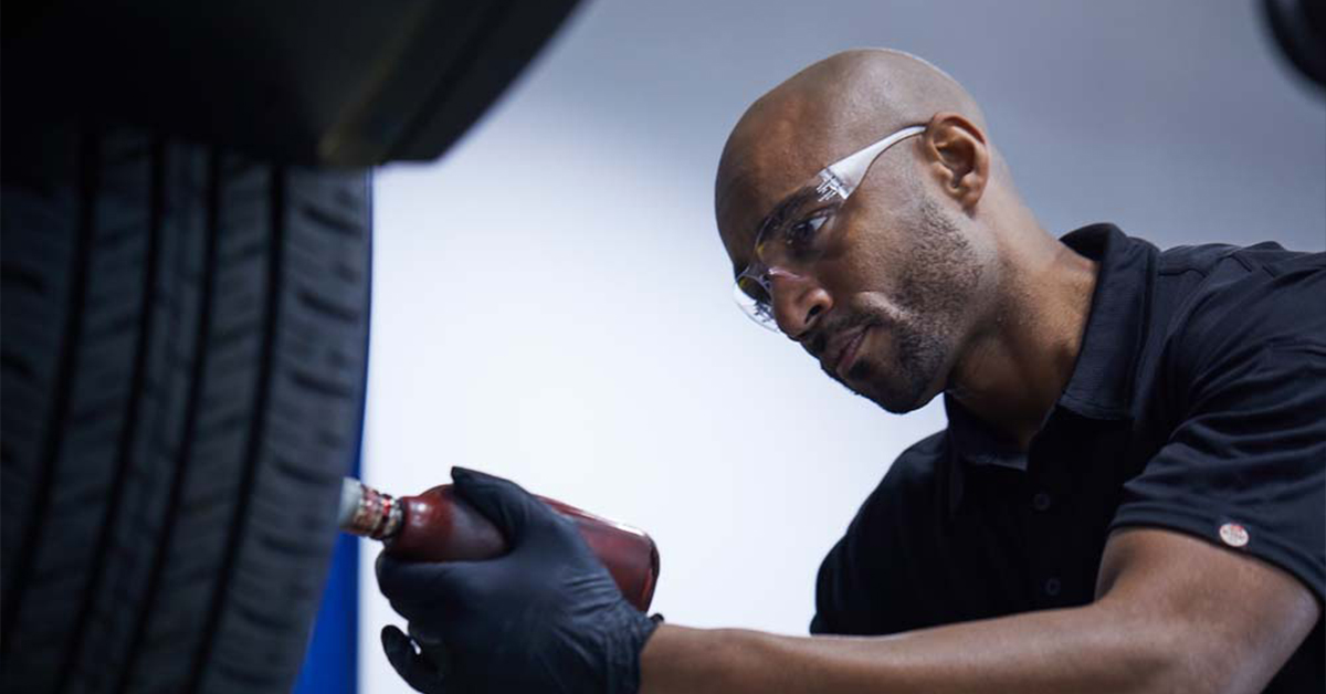 Mazda service technician working on a tire