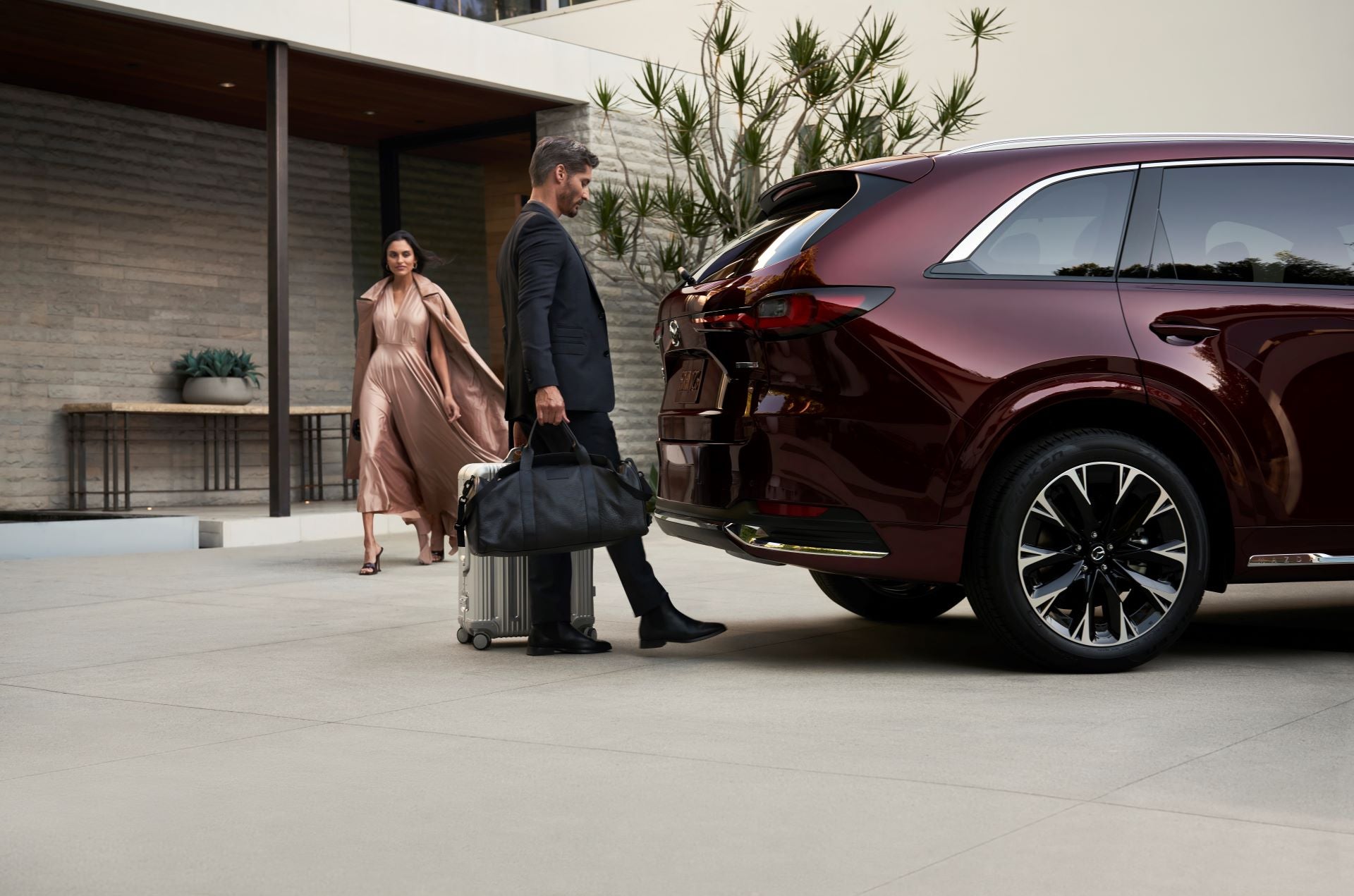 2025 Mazda CX-90 with hands-free tailgate open, showing rear cargo access in a driveway.
